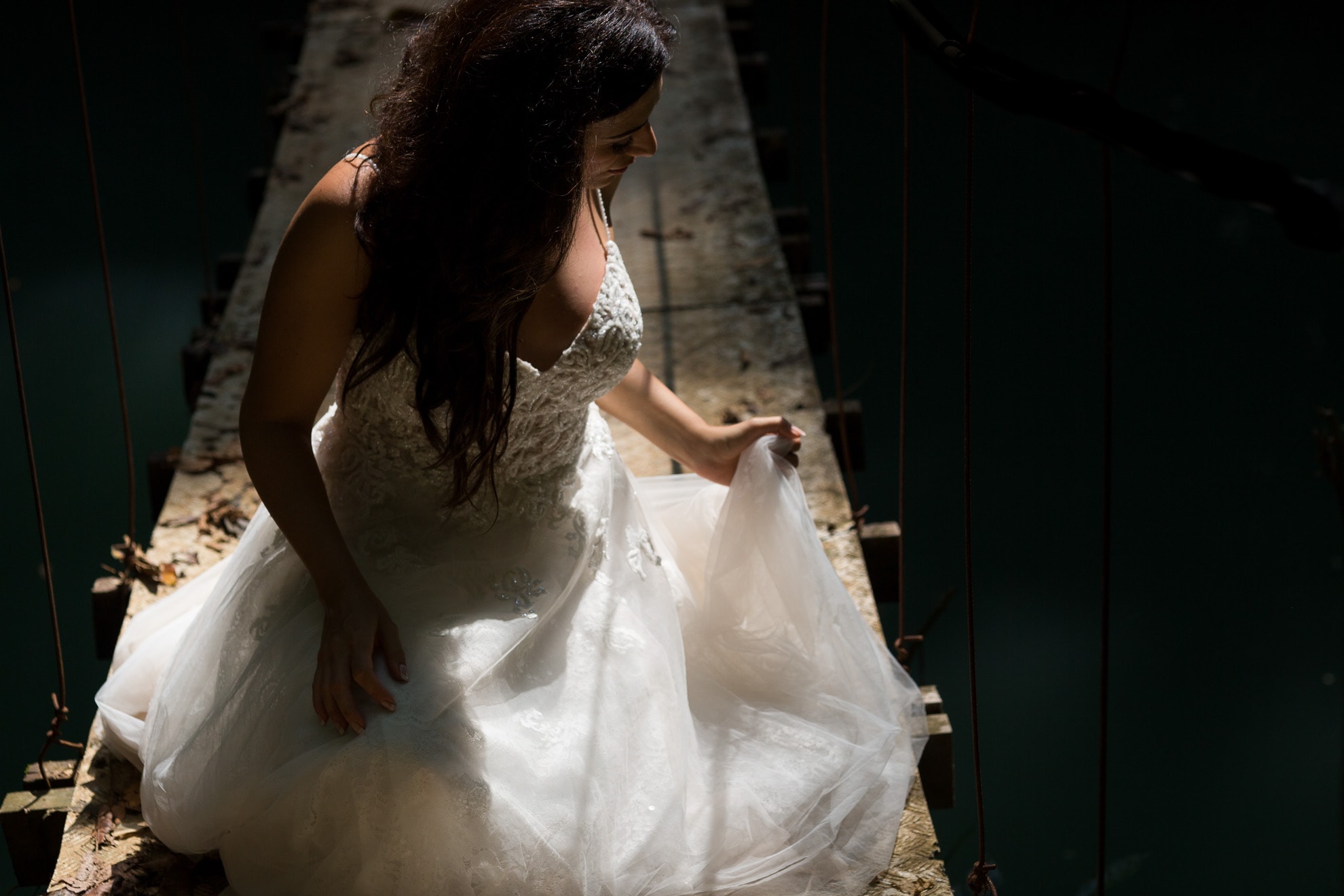 Bride on hanging bridge adjust dress