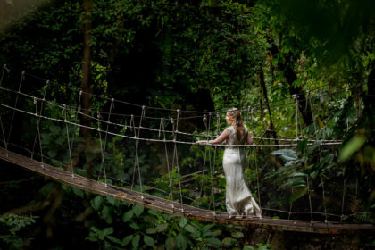The bride strolling across a hanging bridge in the Costa Rican rainforest