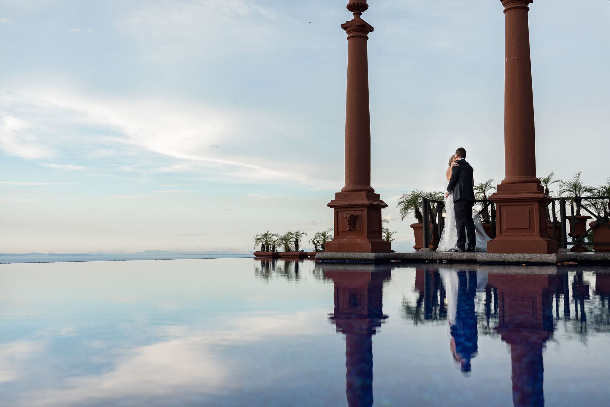 A beautiful moment of just the couple with the infinity pool and the sky