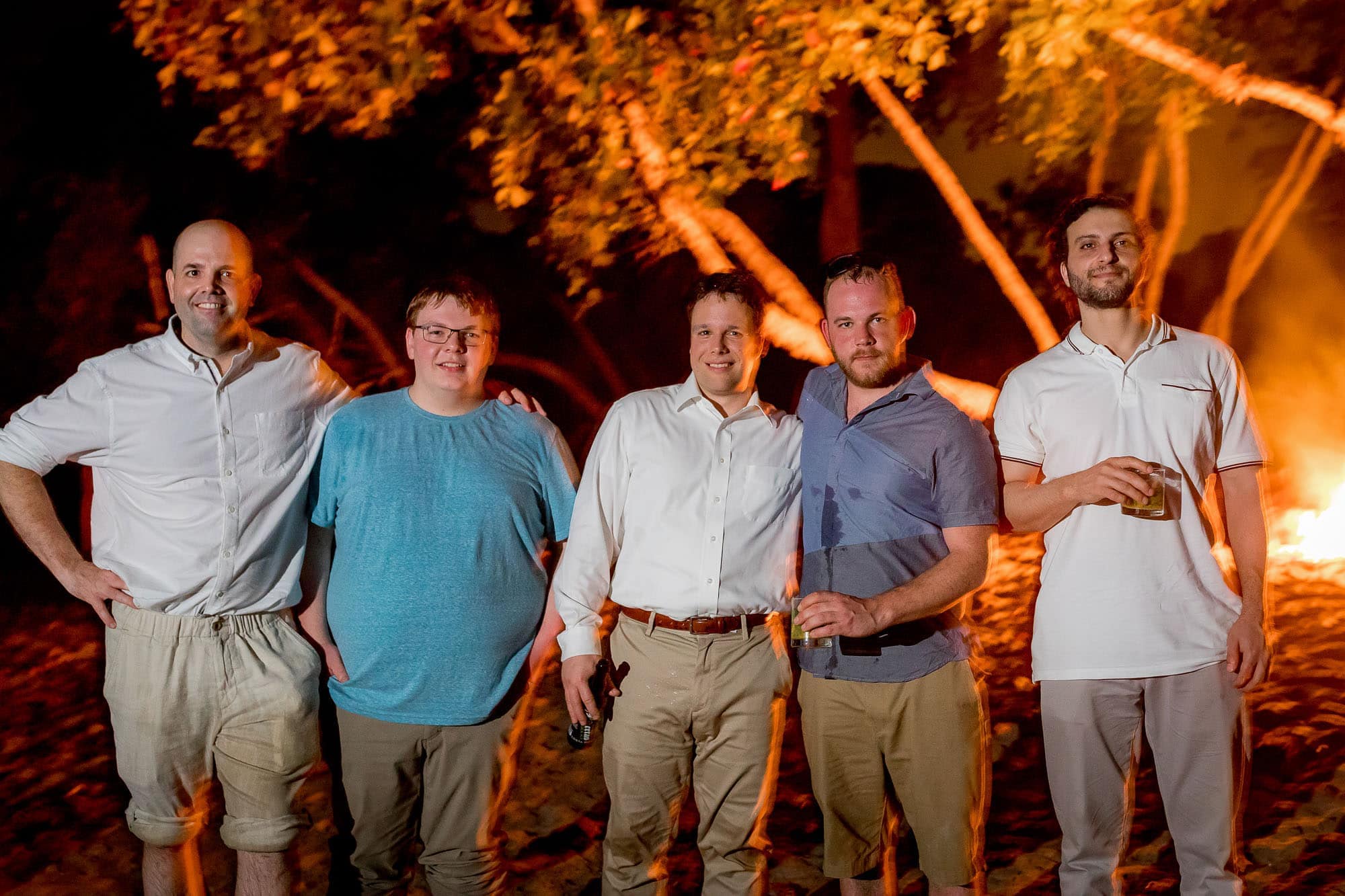 The groom with his buddies in front of the bonfire
