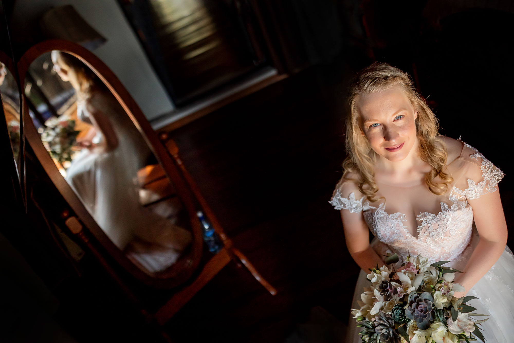 Creative wedding shot from above with the bride reflected in the mirror behind her