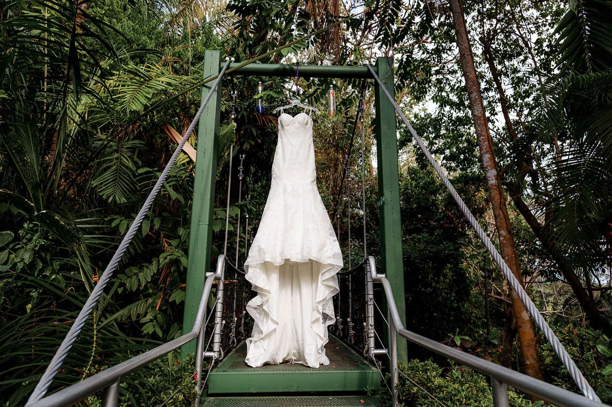 The elegant formal wedding gown hanging in the hanging bridge at Costa Verde