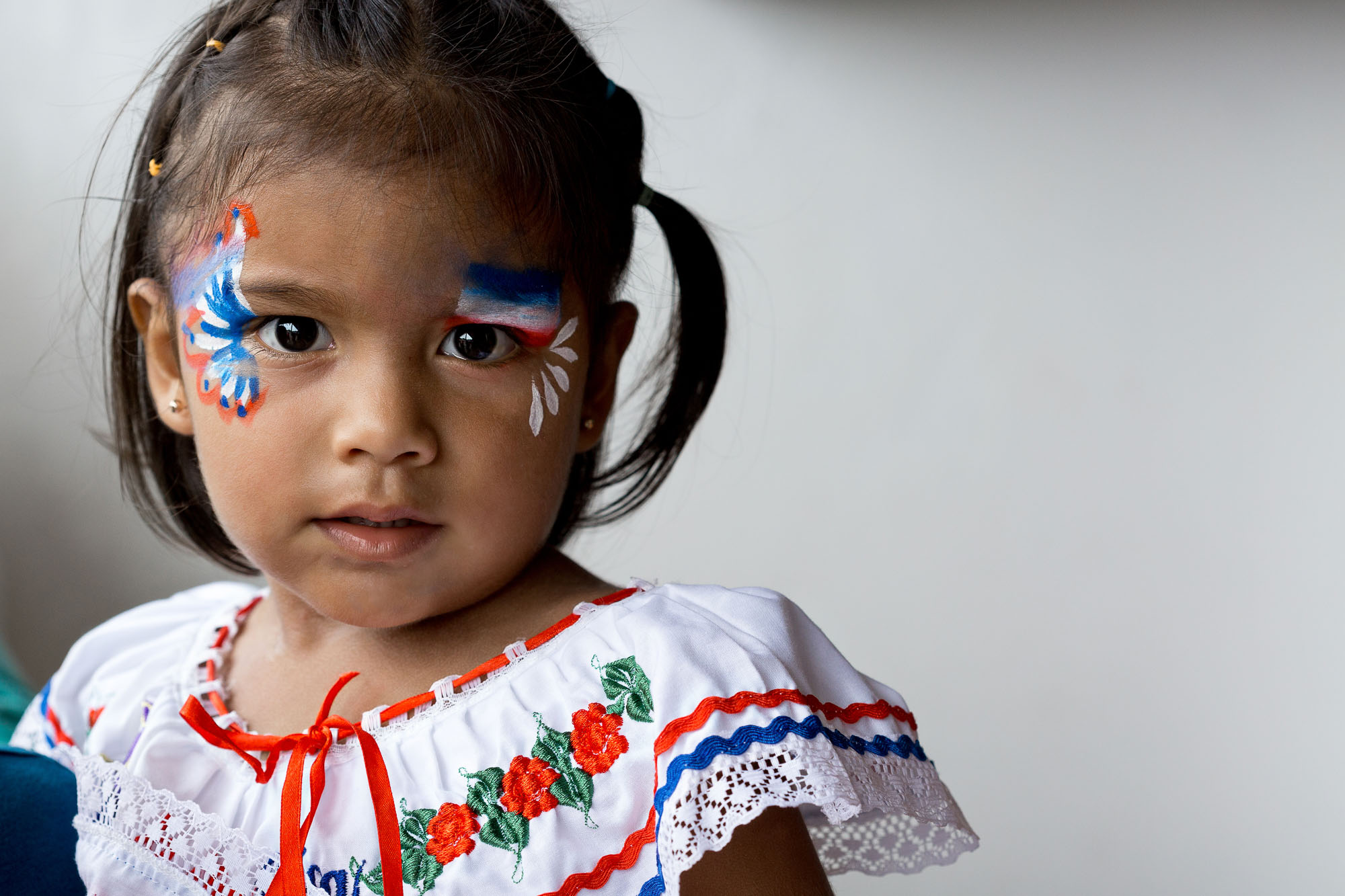 Little girl in campesino outfit (traditional Costa Rican clothing) with face paint