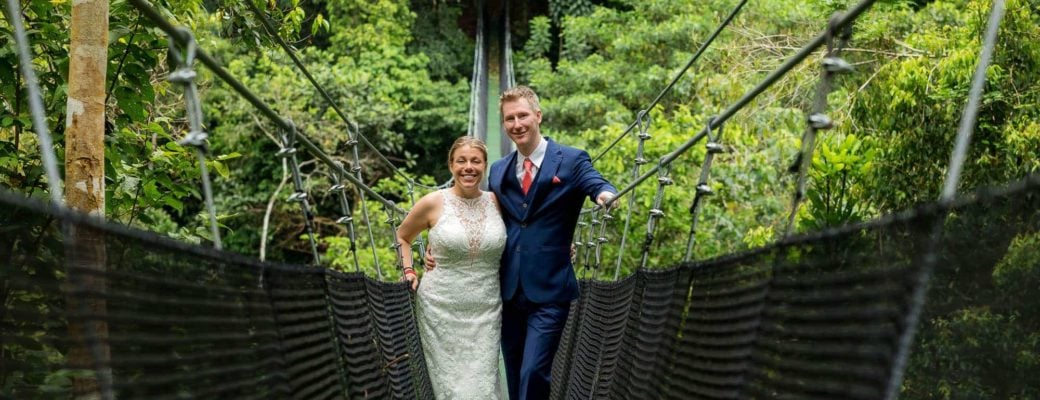 Bride and groom on a suspension bridge above the jungle