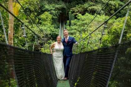 Bride and groom on a suspension bridge above the jungle