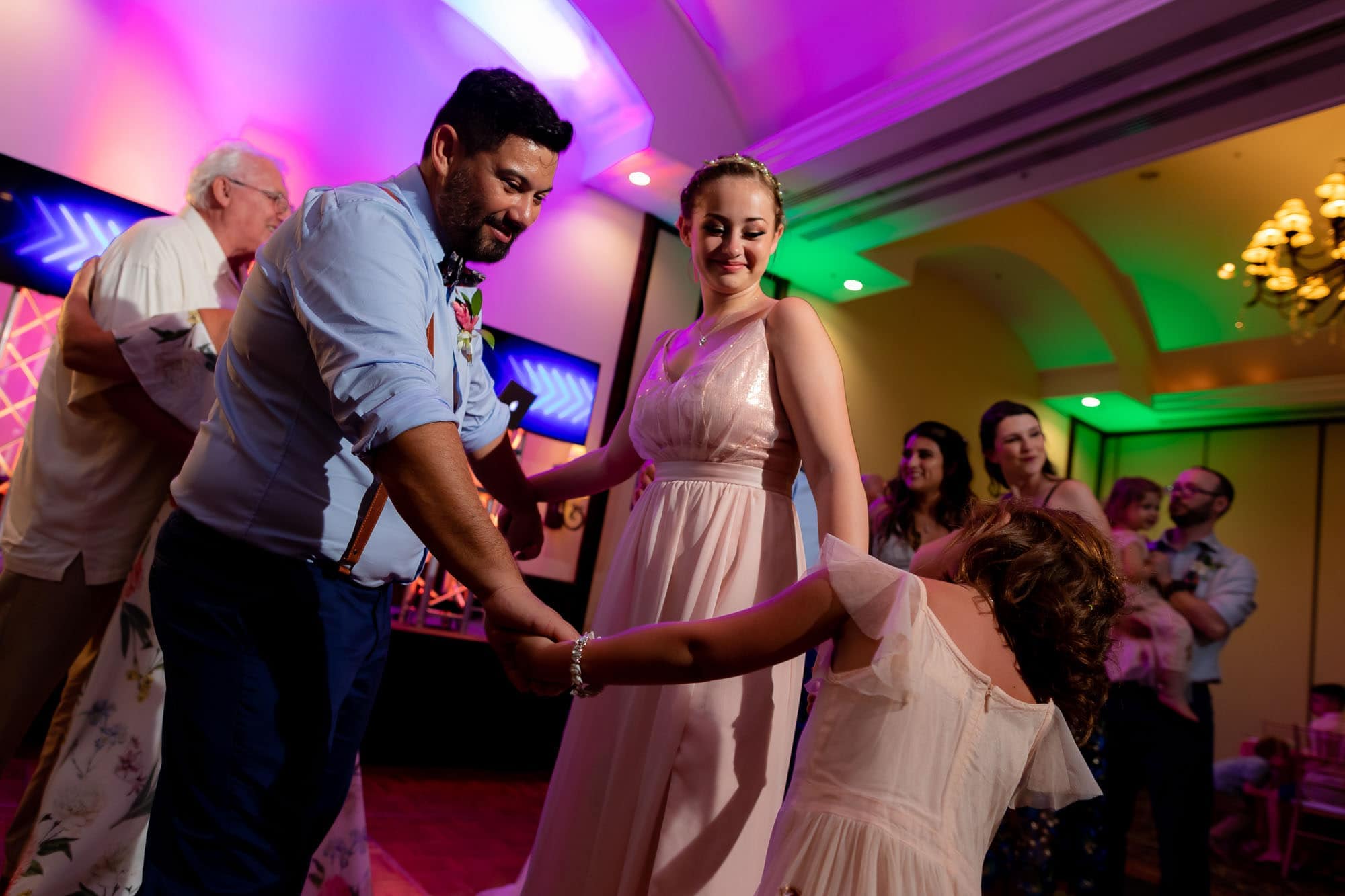 father dancing with daughters at wedding