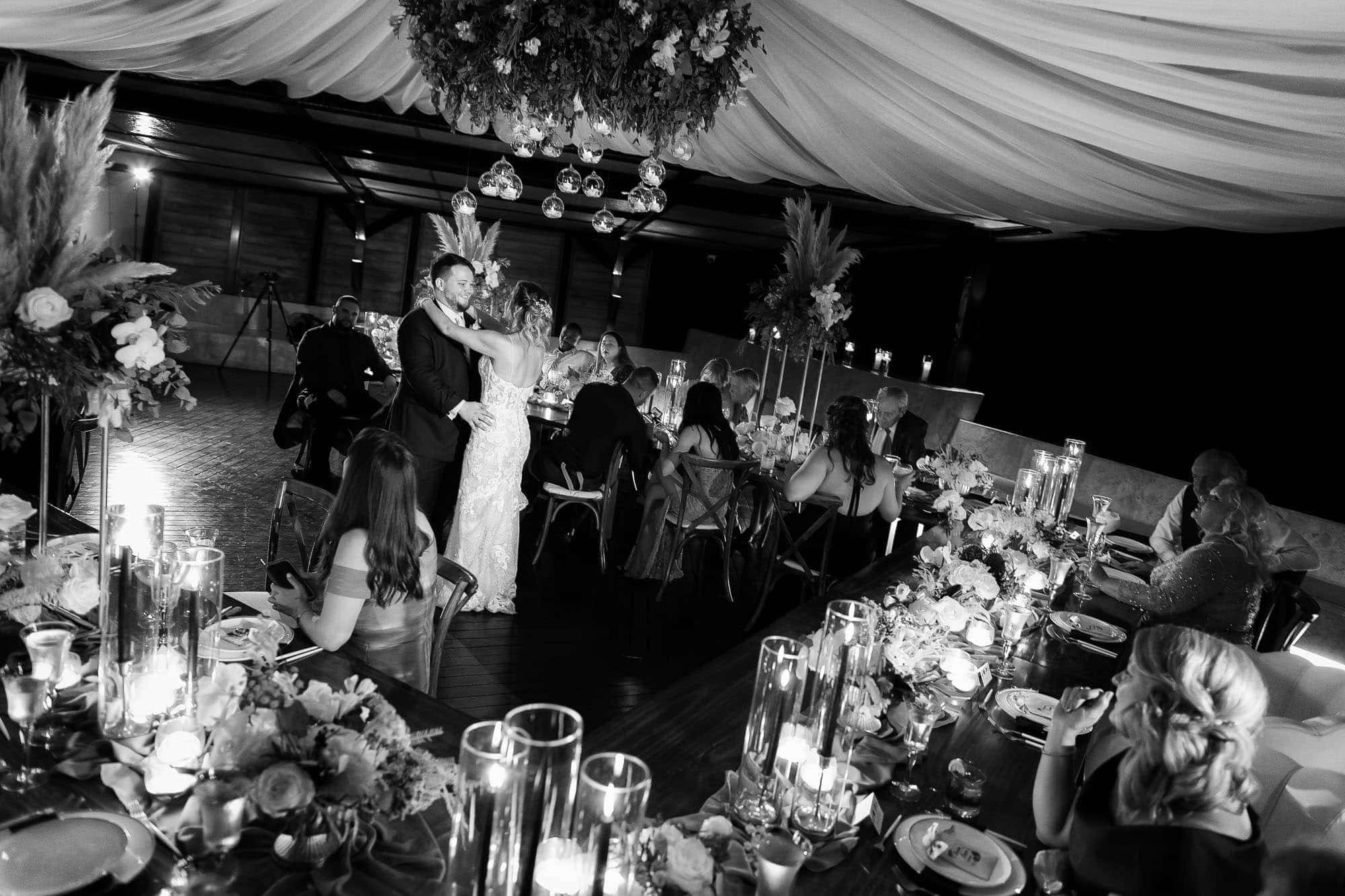 wide shot of the reception space, bride and groom are dancing