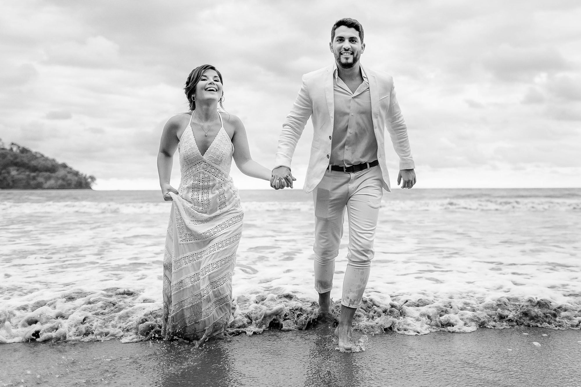 Bride and groom playing in the surf