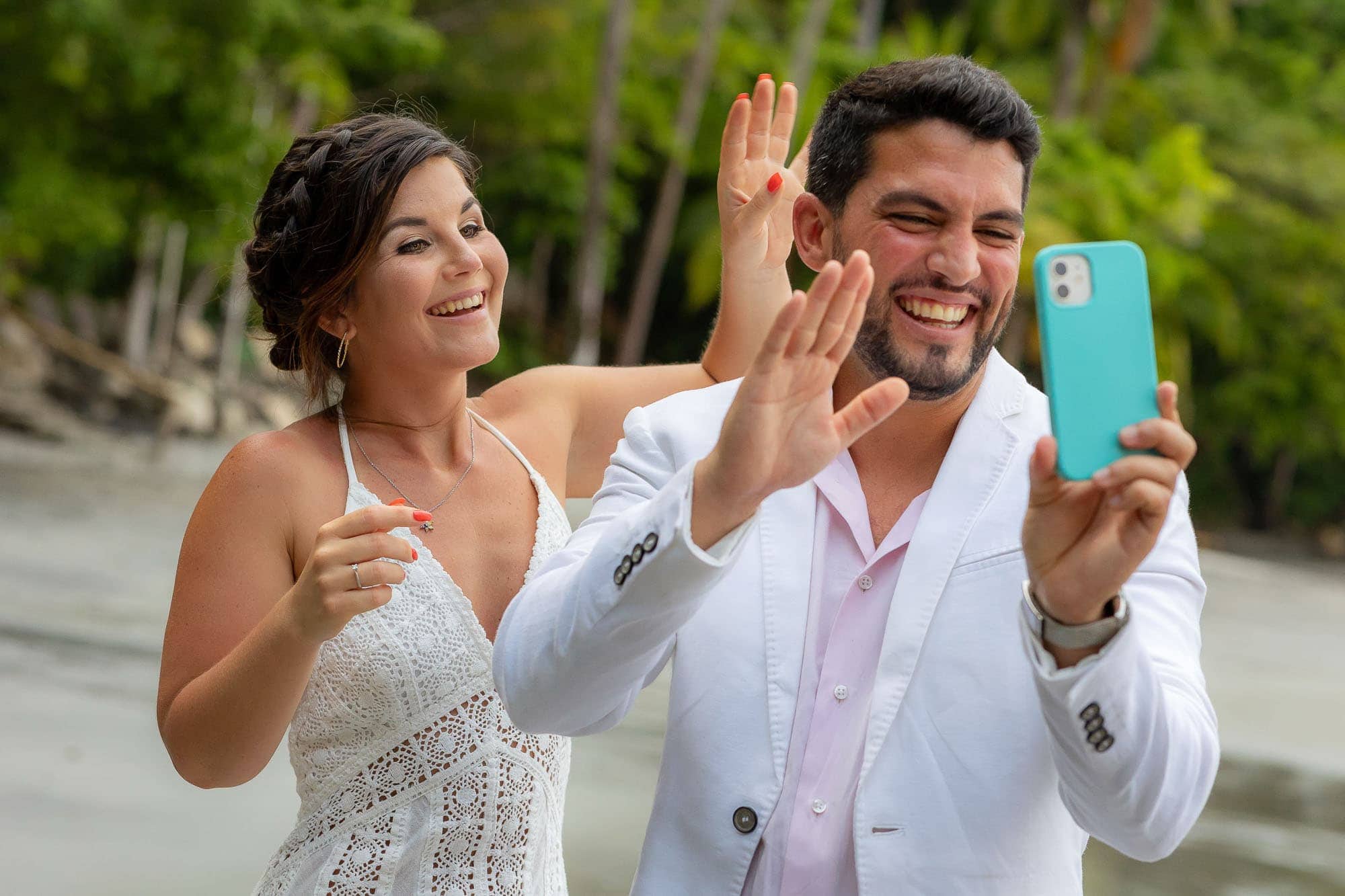 Bride and groom laughing at a cell phone