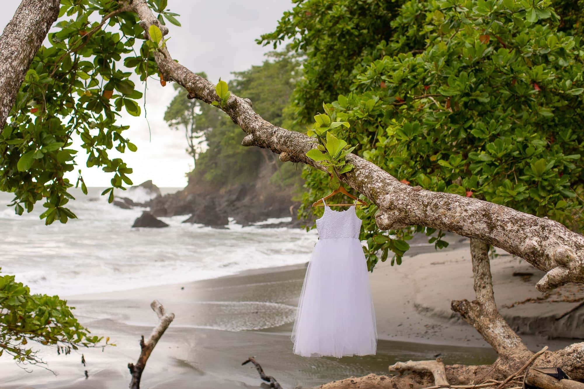 Little girl's white dress hanging on the beach