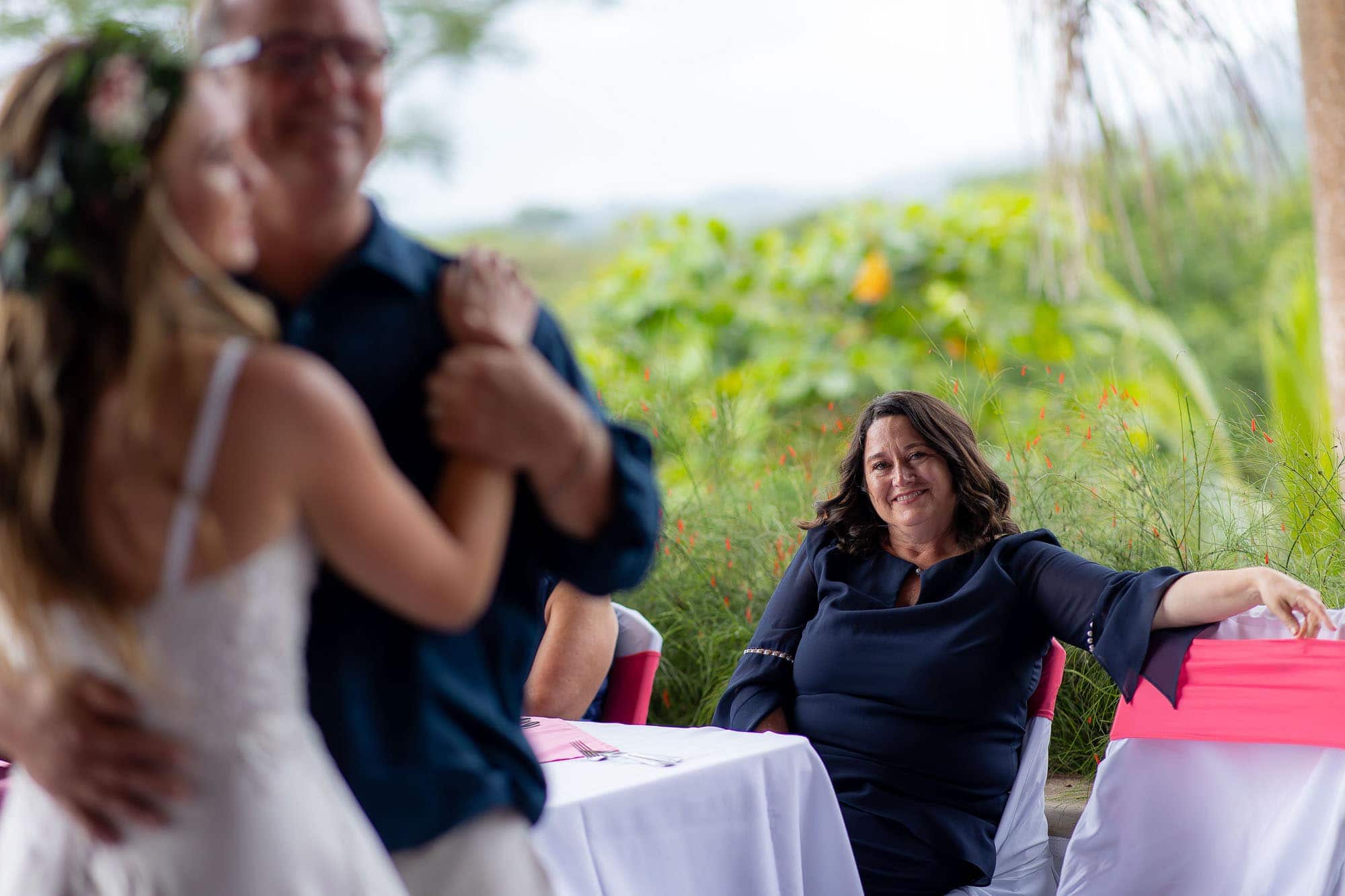 Mom reacts with a smile as bride dances with dad