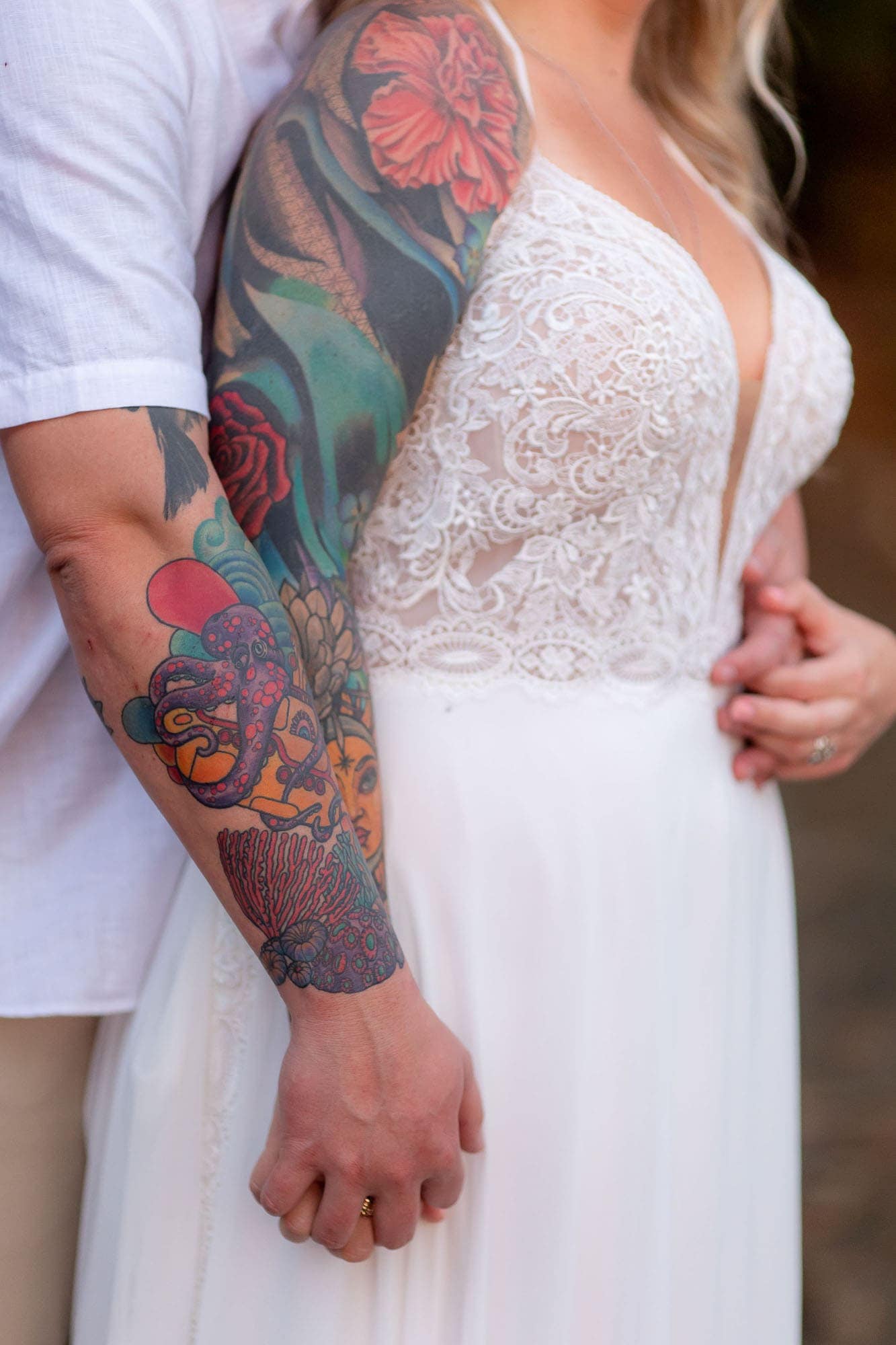 Closeup of the bride and groom's tat sleeves