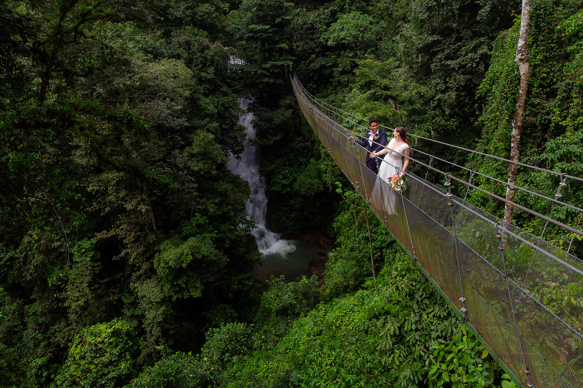 the bride and groom on the hanging bridge