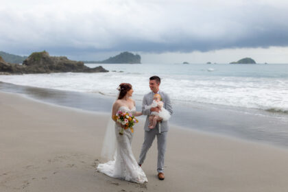 Groom, bride, and baby stroll along the beach at a costa rica wedding