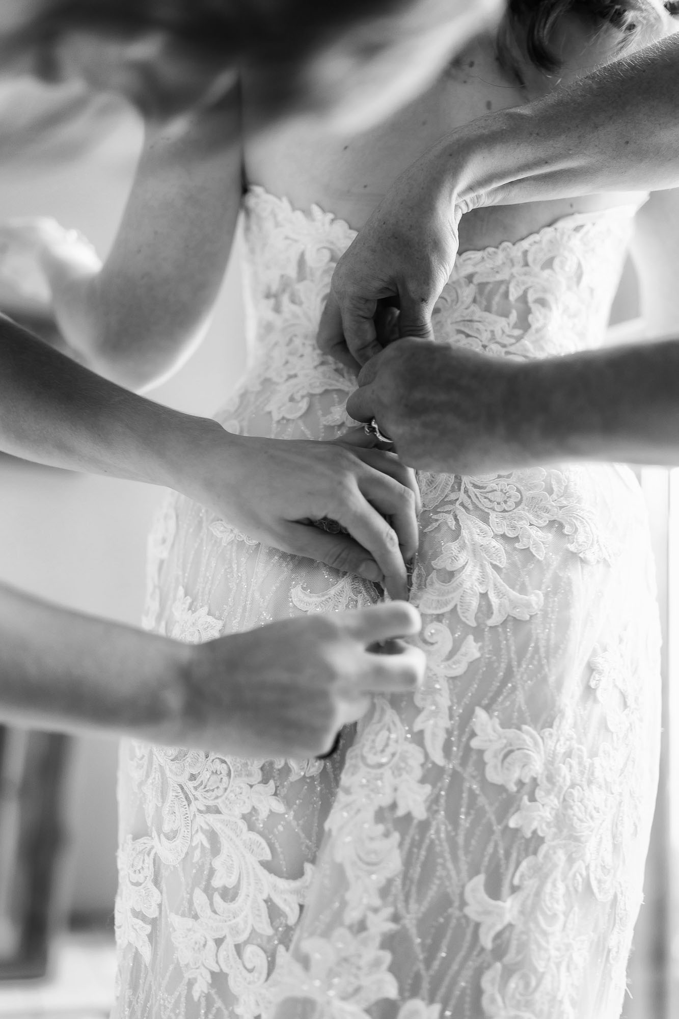 buttoning up the bride's dress