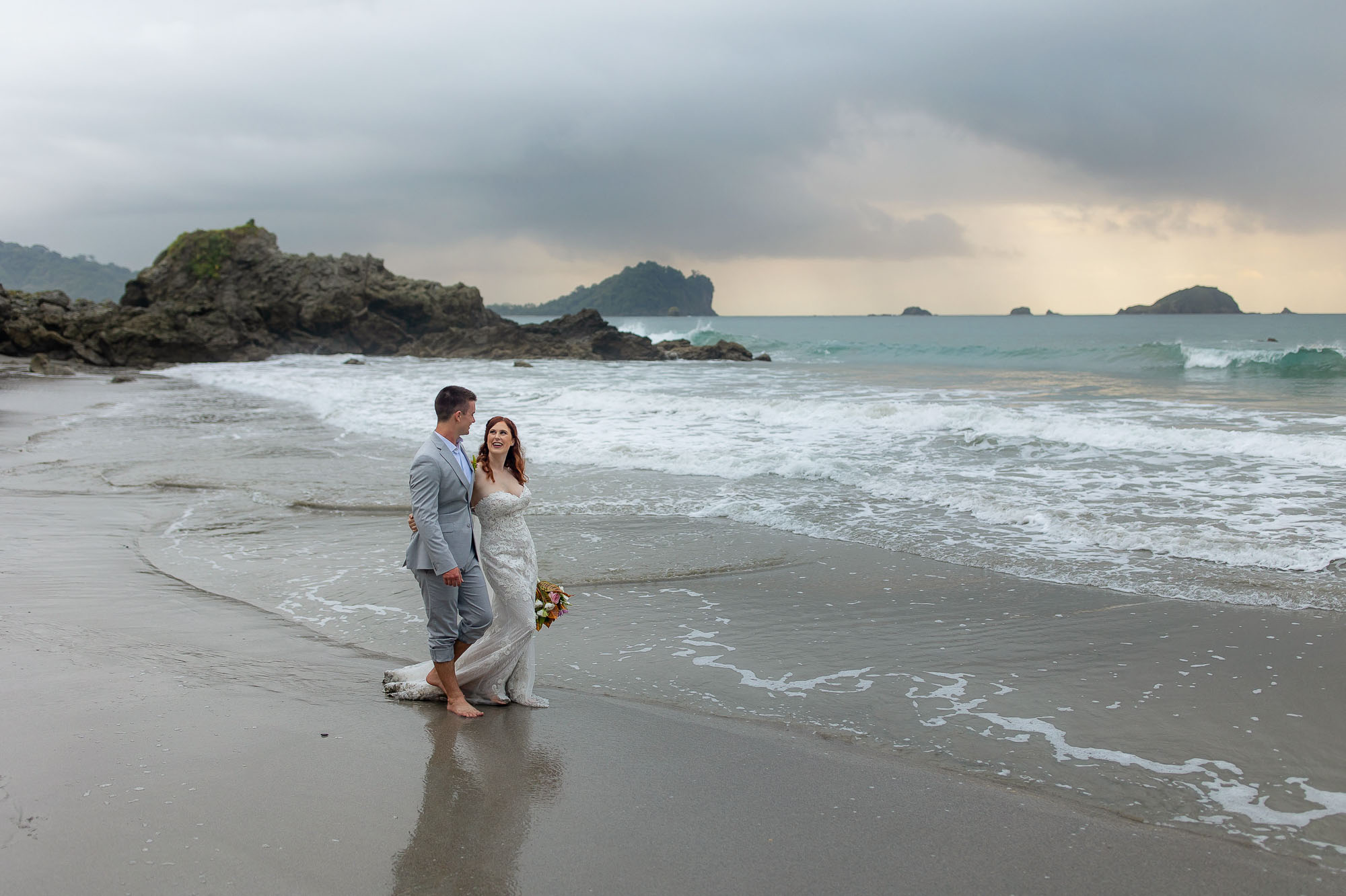 Bride and groom walking along the beach after a Costa Rica wedding