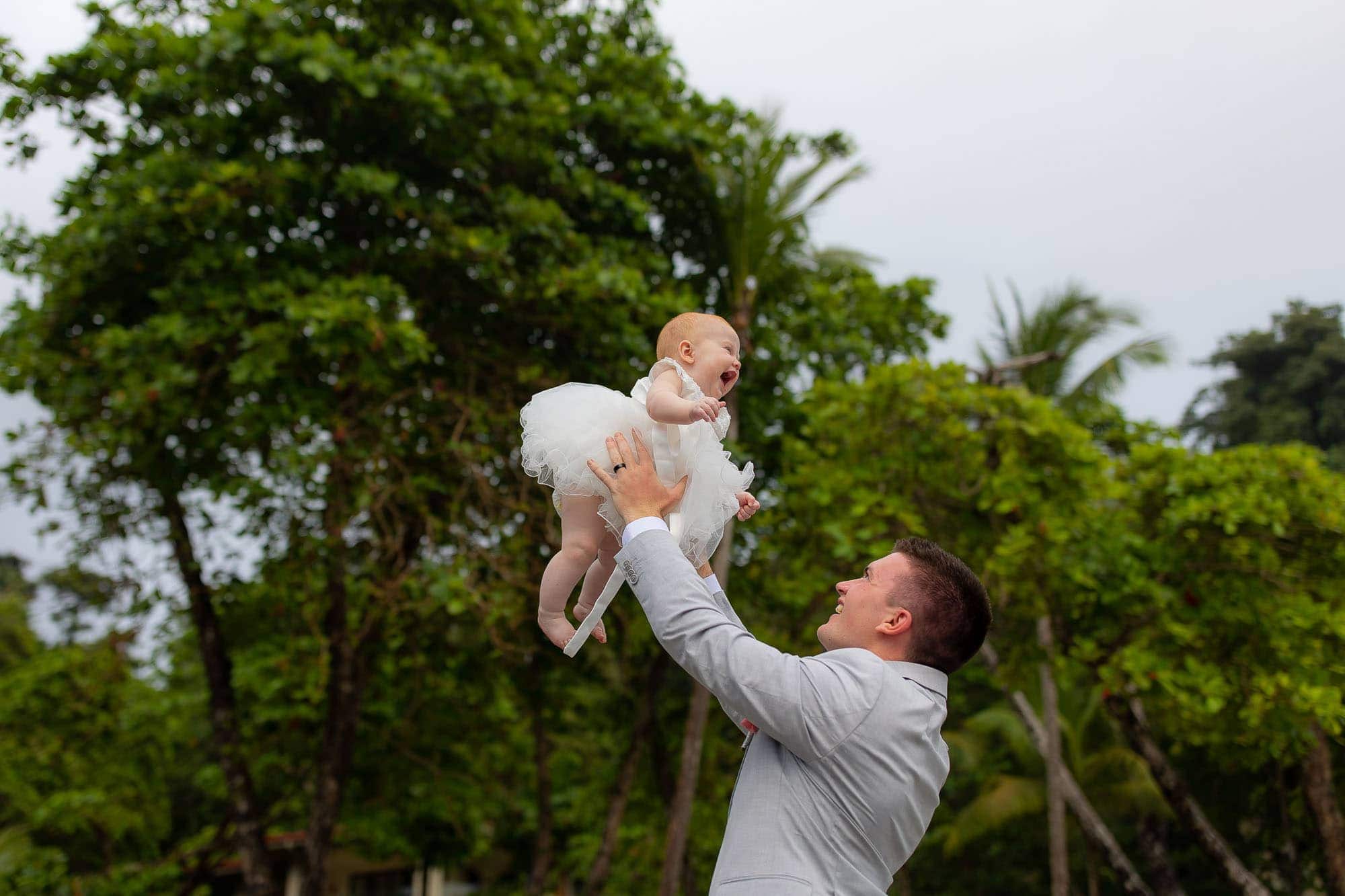 Groom tosses delighted baby in the air