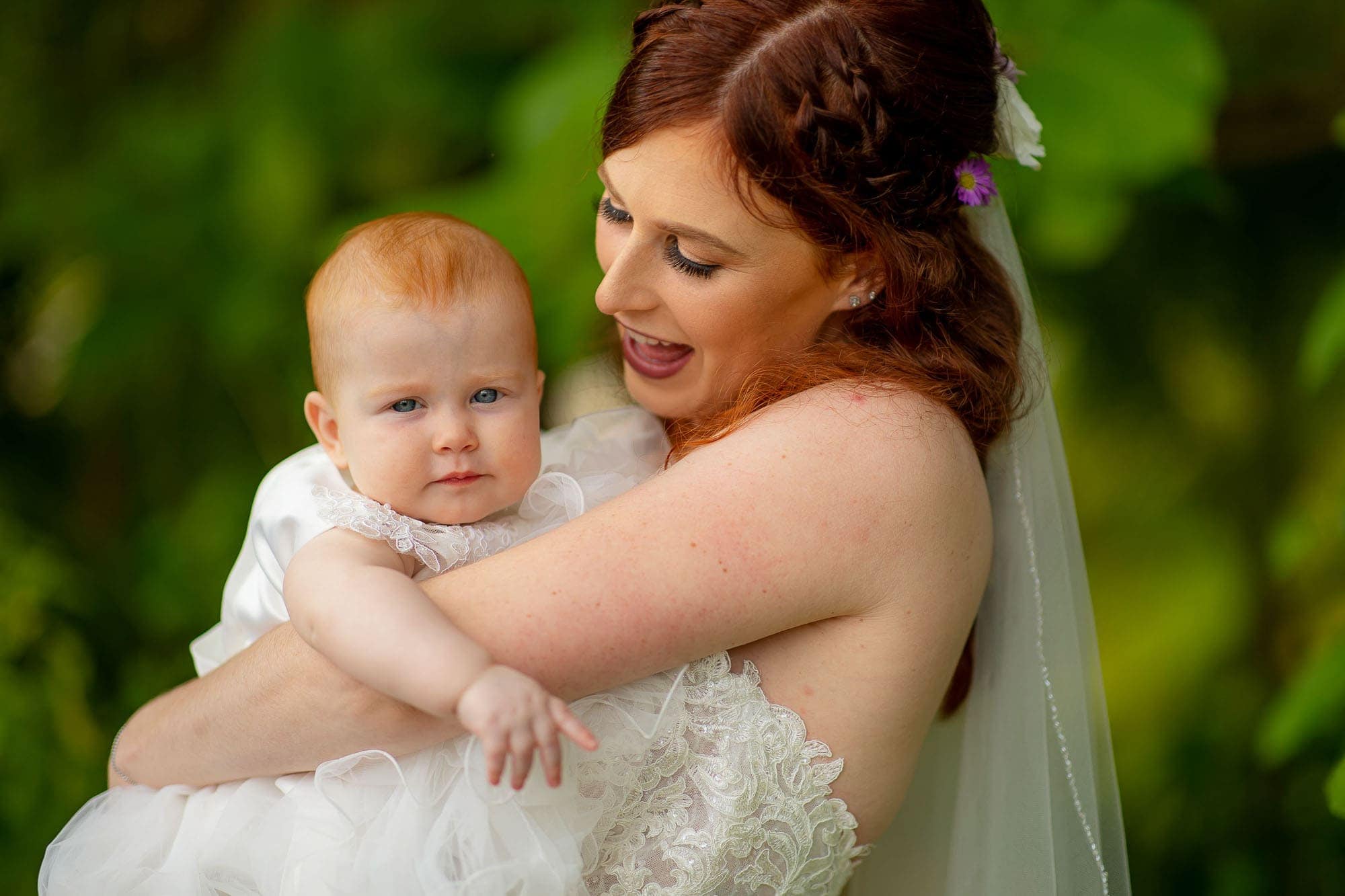 Bride snuggles with baby