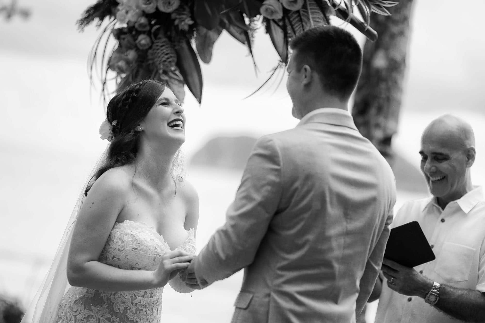 bride laughing with groom at the altar