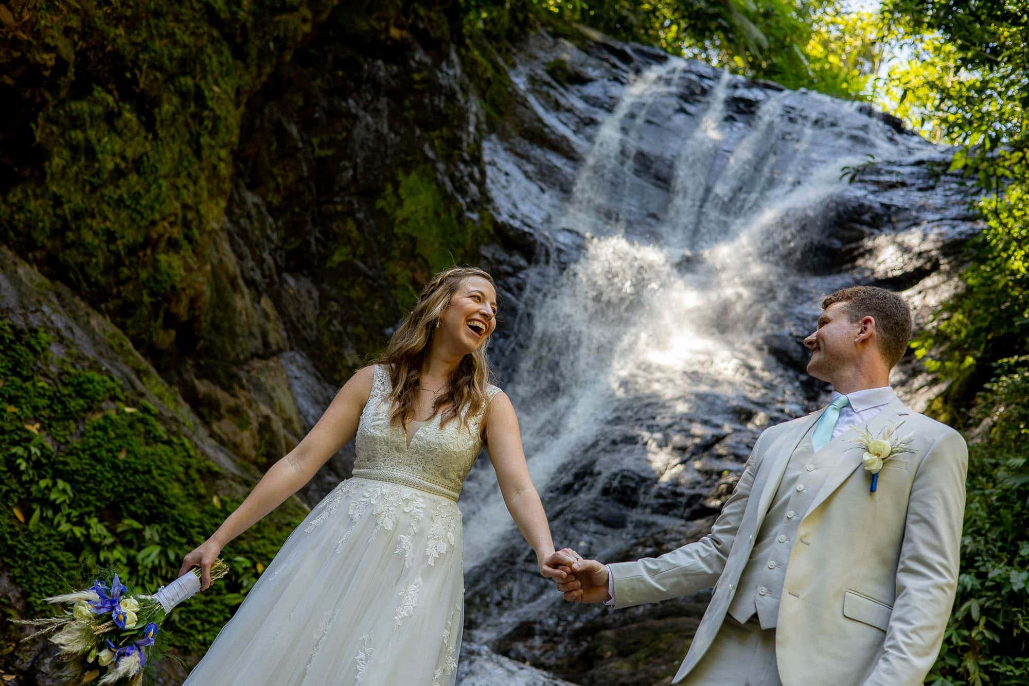 bride and groom at the base of the waterfall