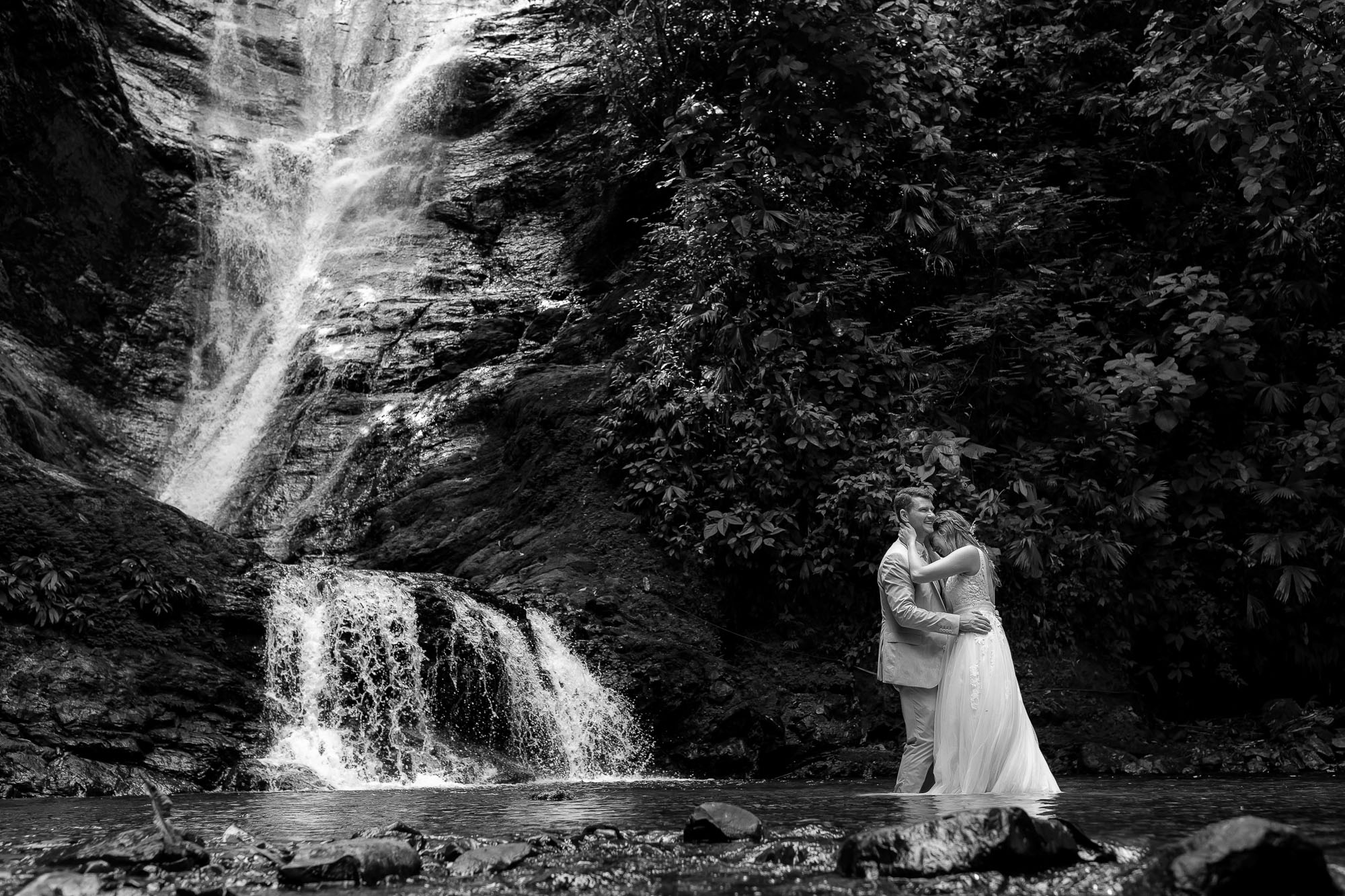 Waterfall wedding: bride and groom in the water