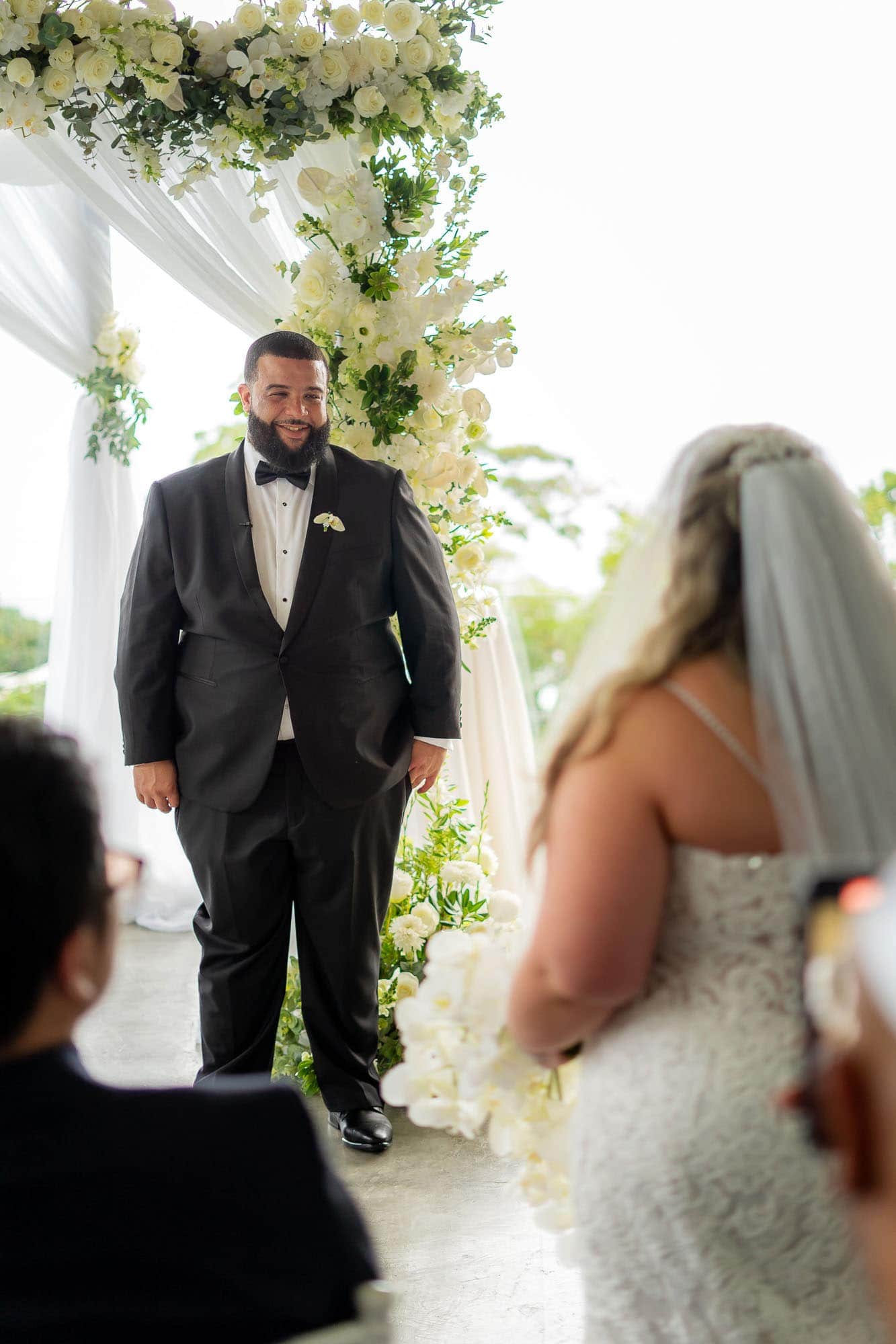Groom smiles as he sees his bride approach