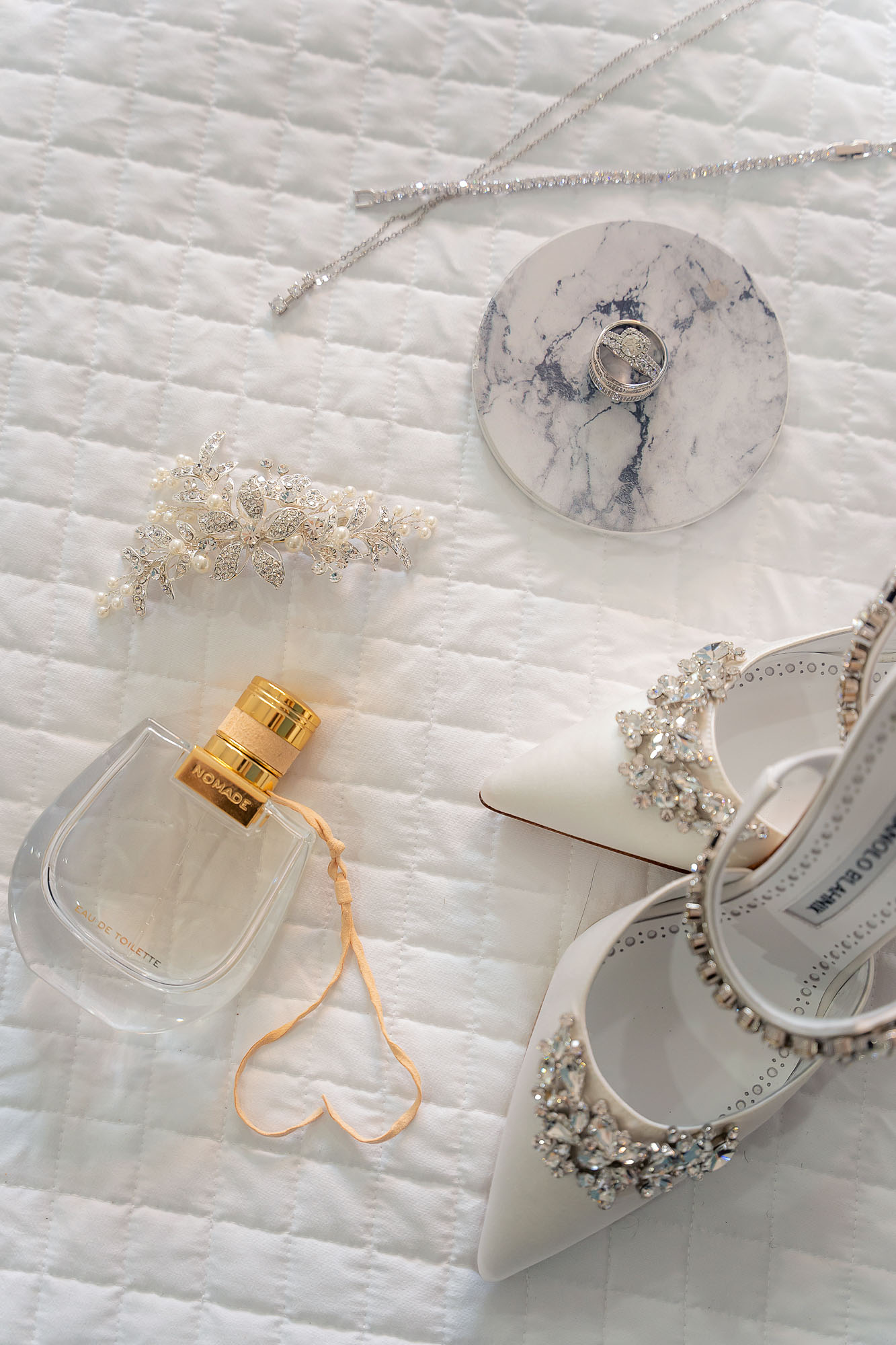 Pretty wedding details, shoes, rings, hairpiece, and perfume bottle