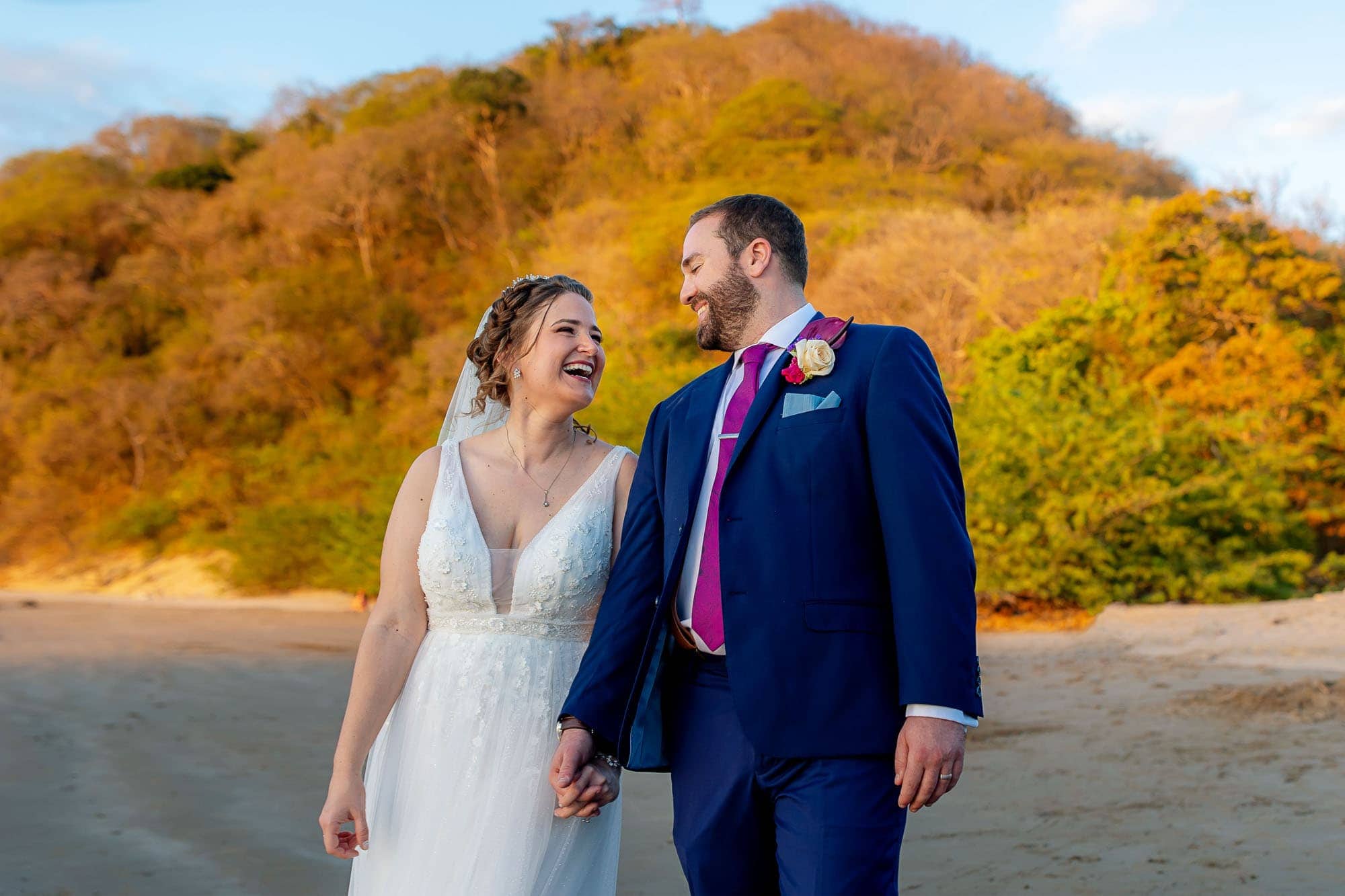 Bride and groom laughing on the beach
