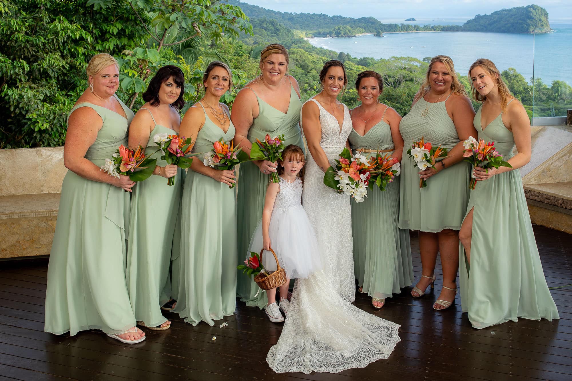 Bride with seven bridesmaids and the flower girl in front of the view