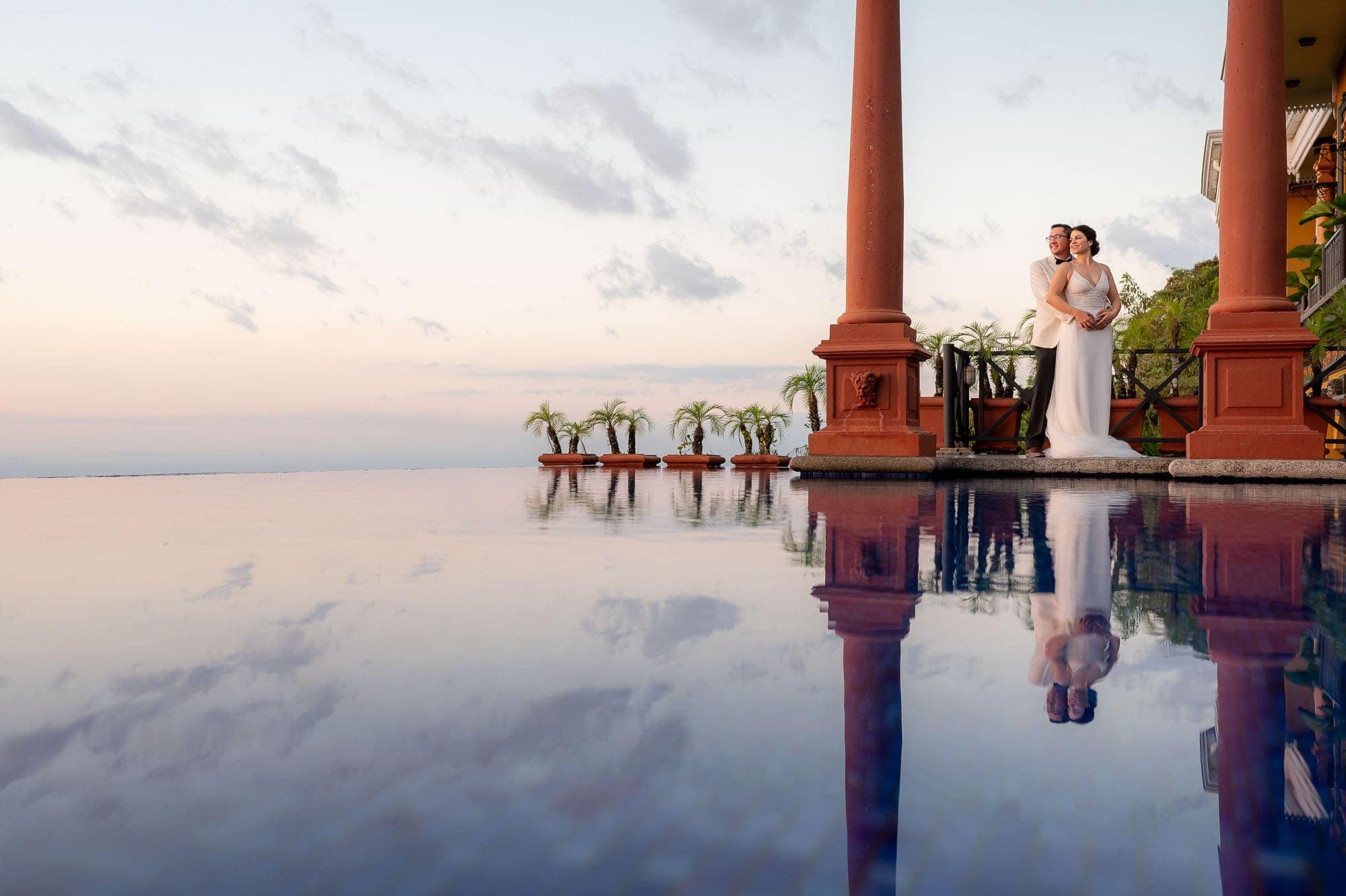 Bride and groom and their reflection in the pool