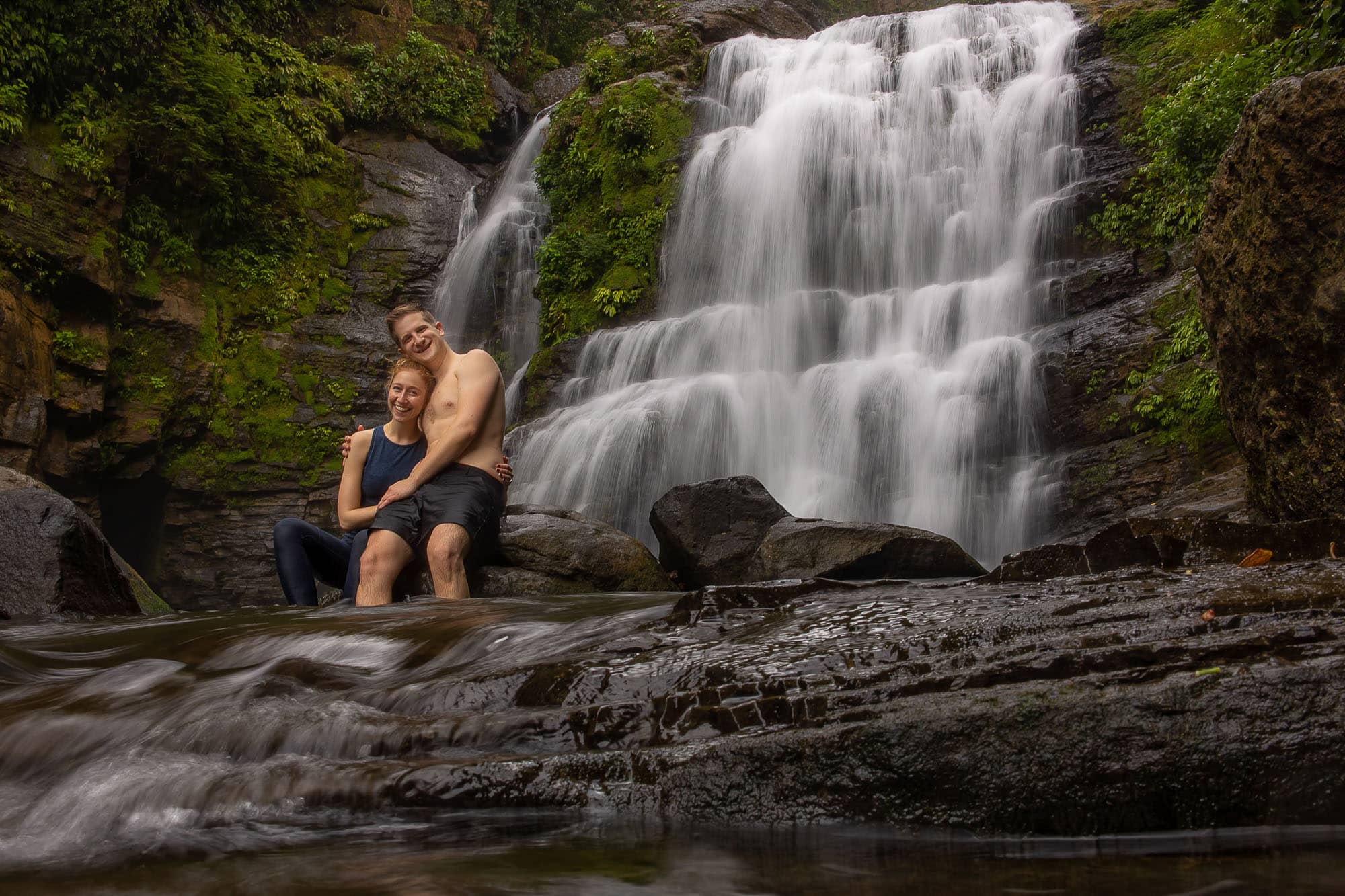 couple sitting with waterfall