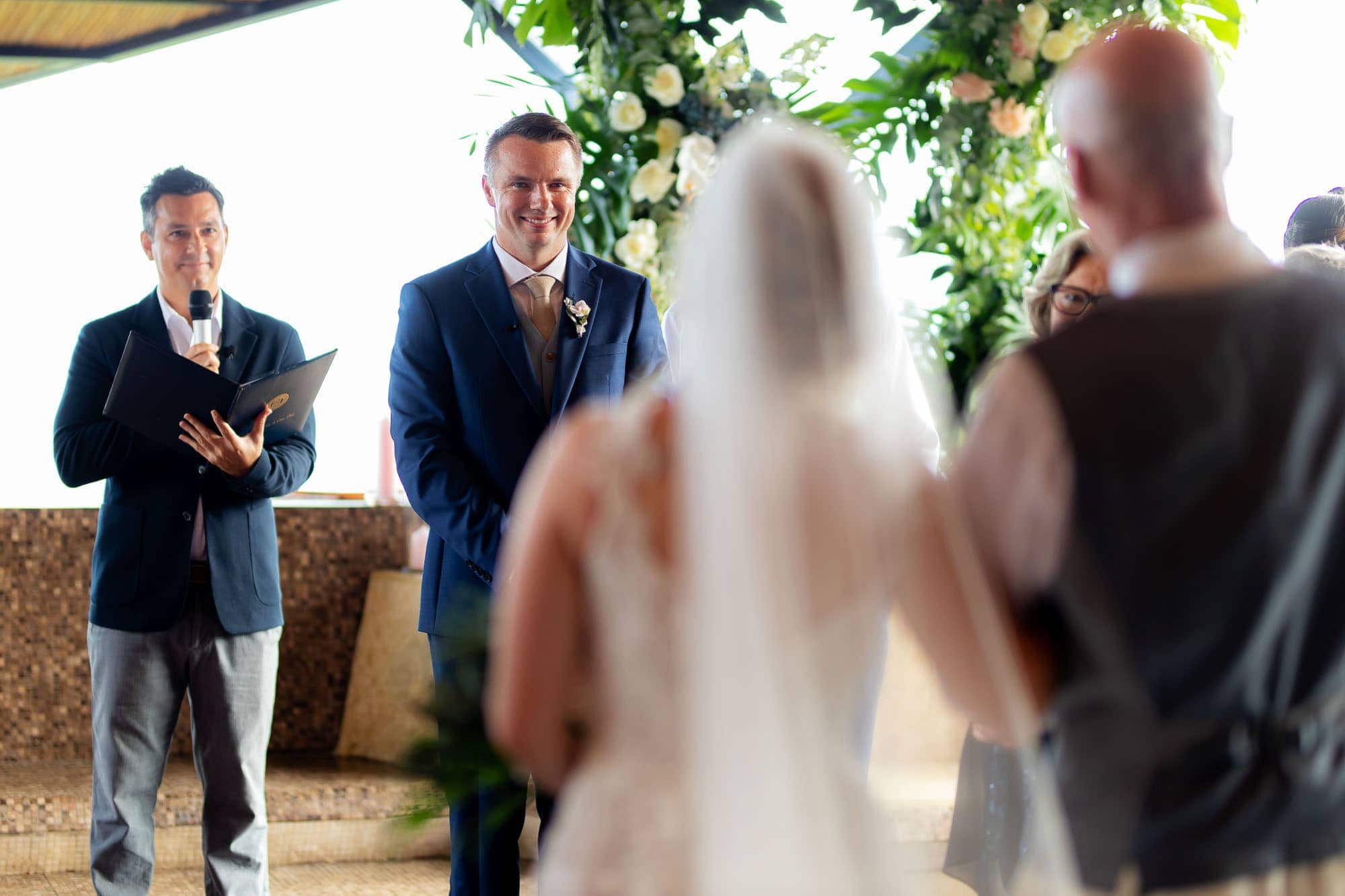 second photographer angle of groom seeing bride walk down aisle