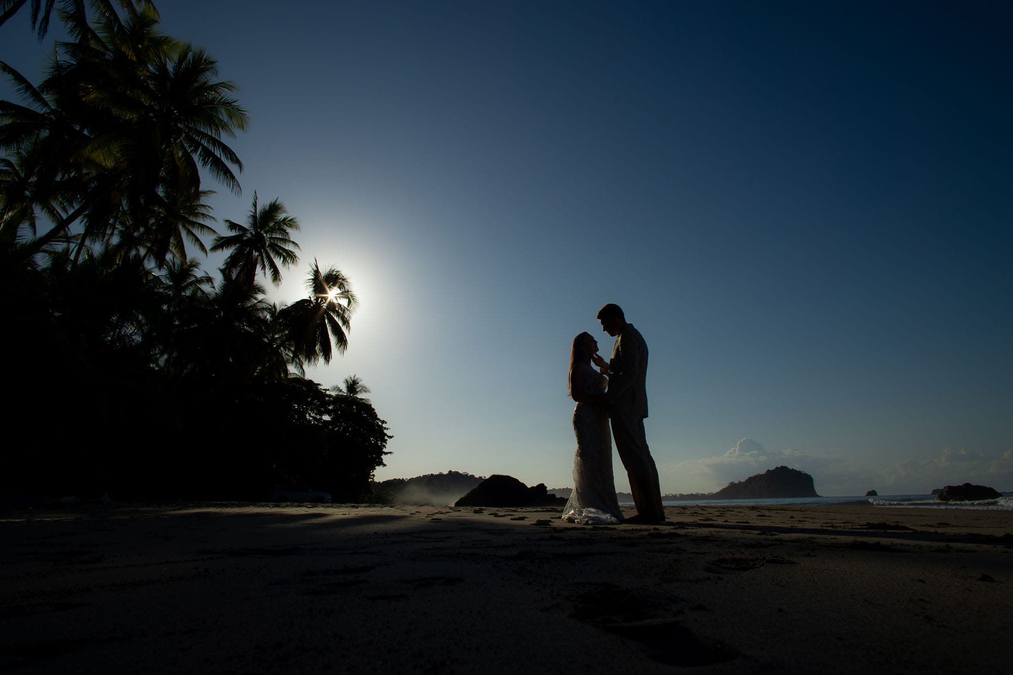 cool silhouette shot of the bride and groom on the beach