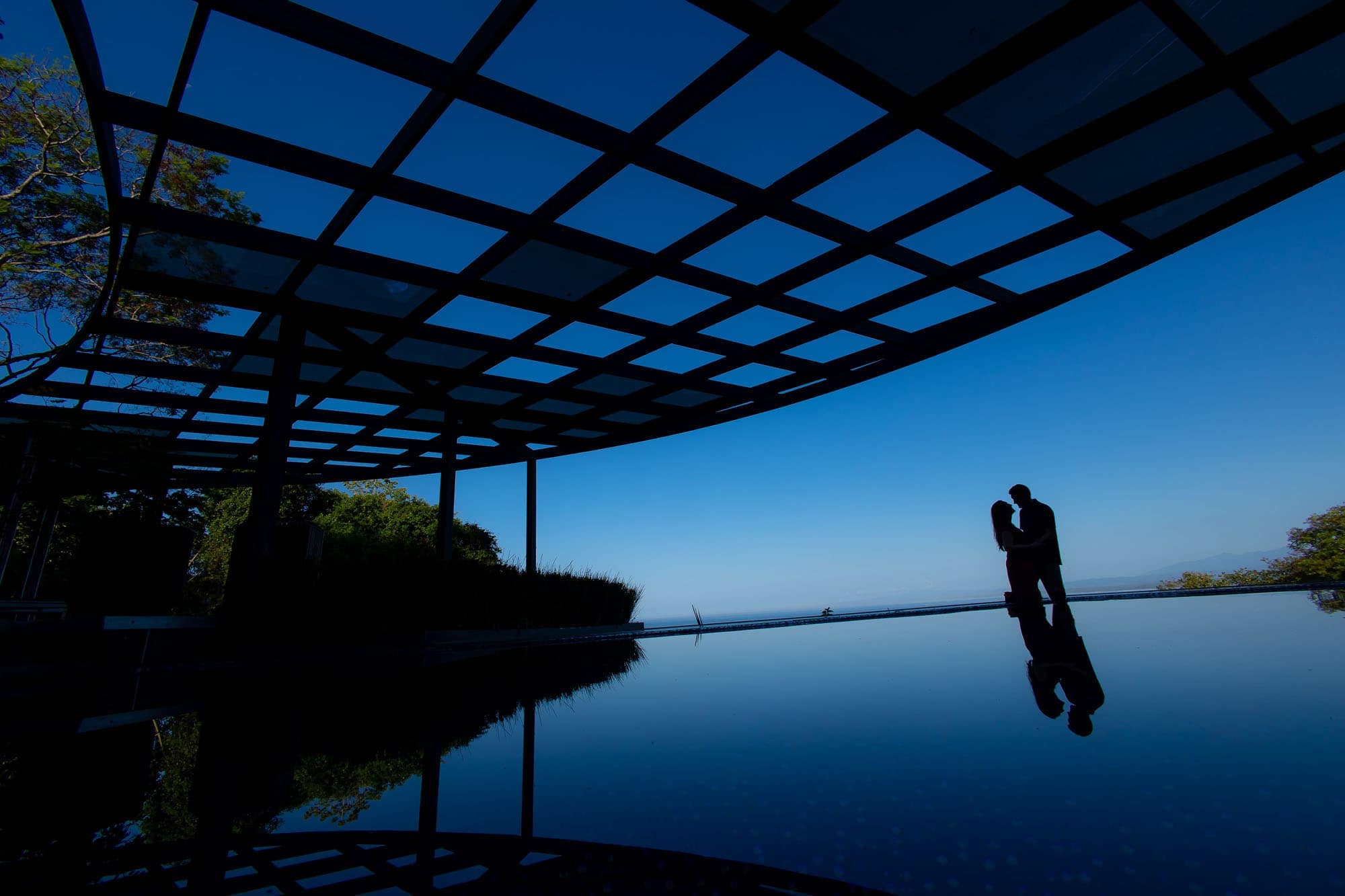 reflection of the bride and groom's silhouette on the pool