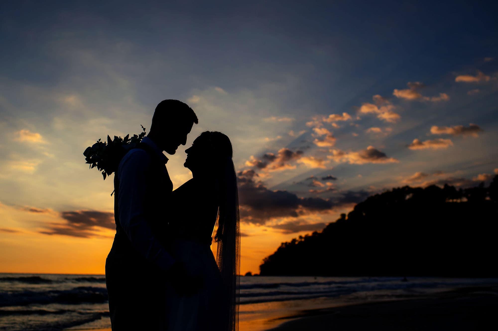 Silhouette images of the bride and groom on the beach
