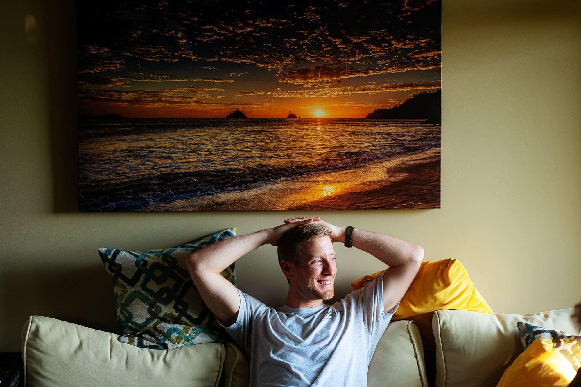 The groom seated under a stunning painting of a sunset