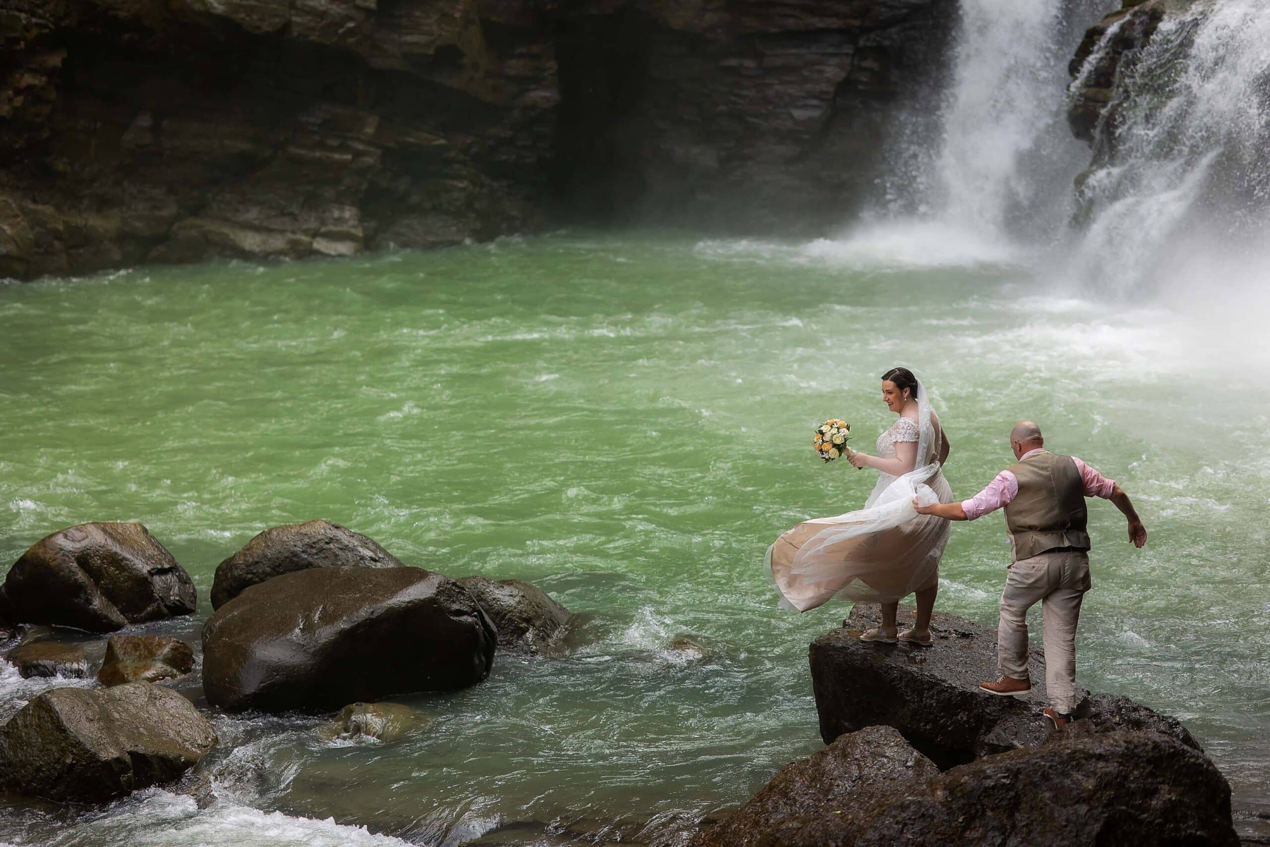 bride and groom at waterfall