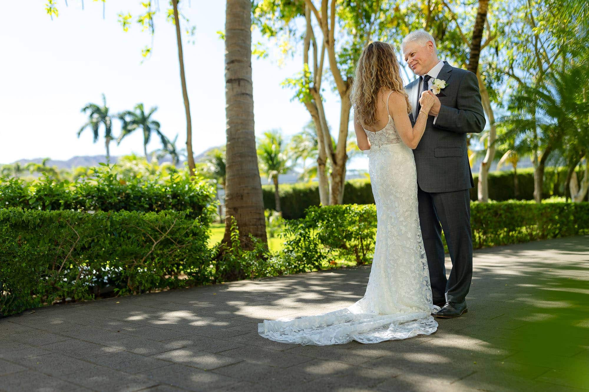 bride and groom stroll along a shaded path at Riu palace costa rica