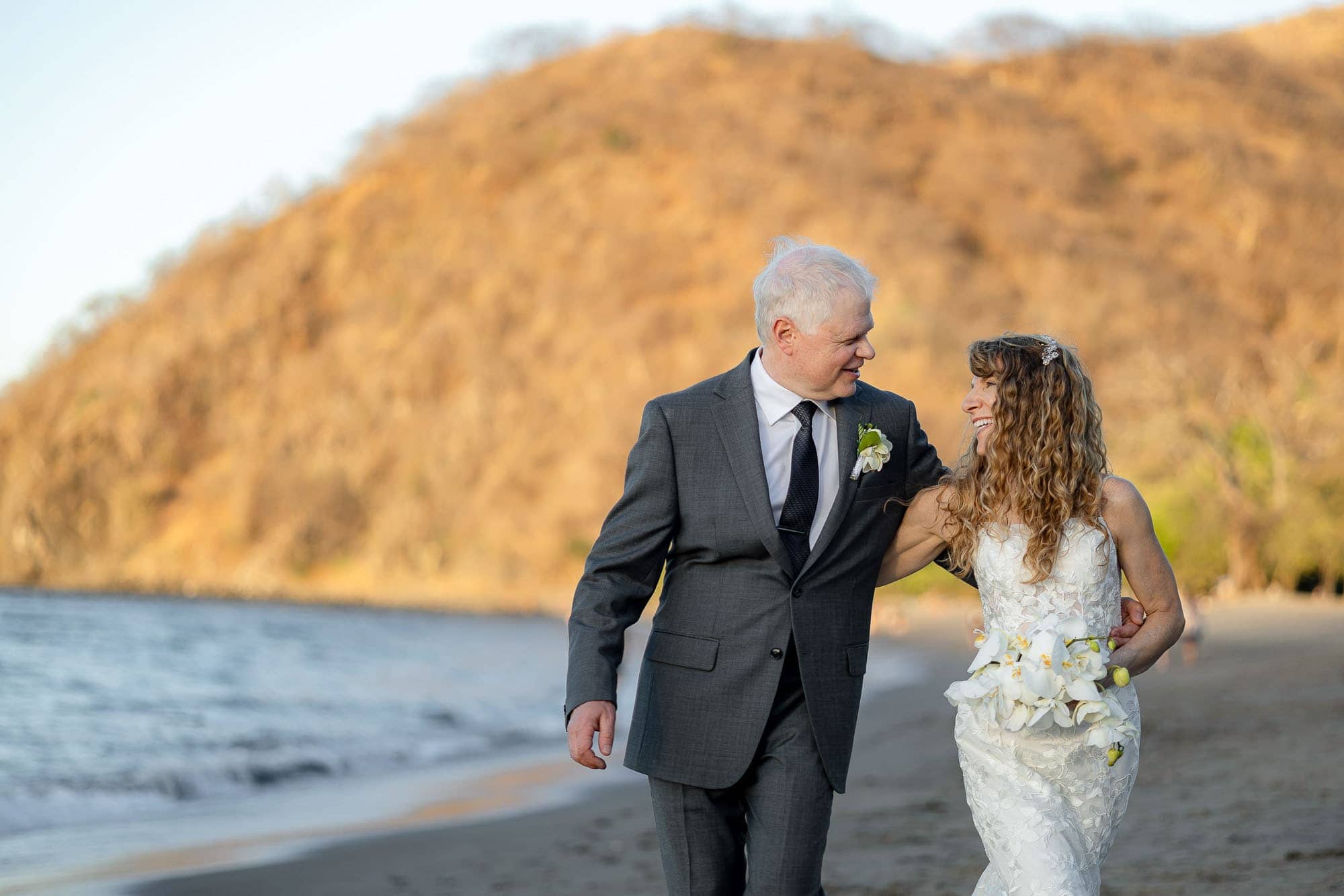 bride and groom stroll along the beach at riu palace costa rica