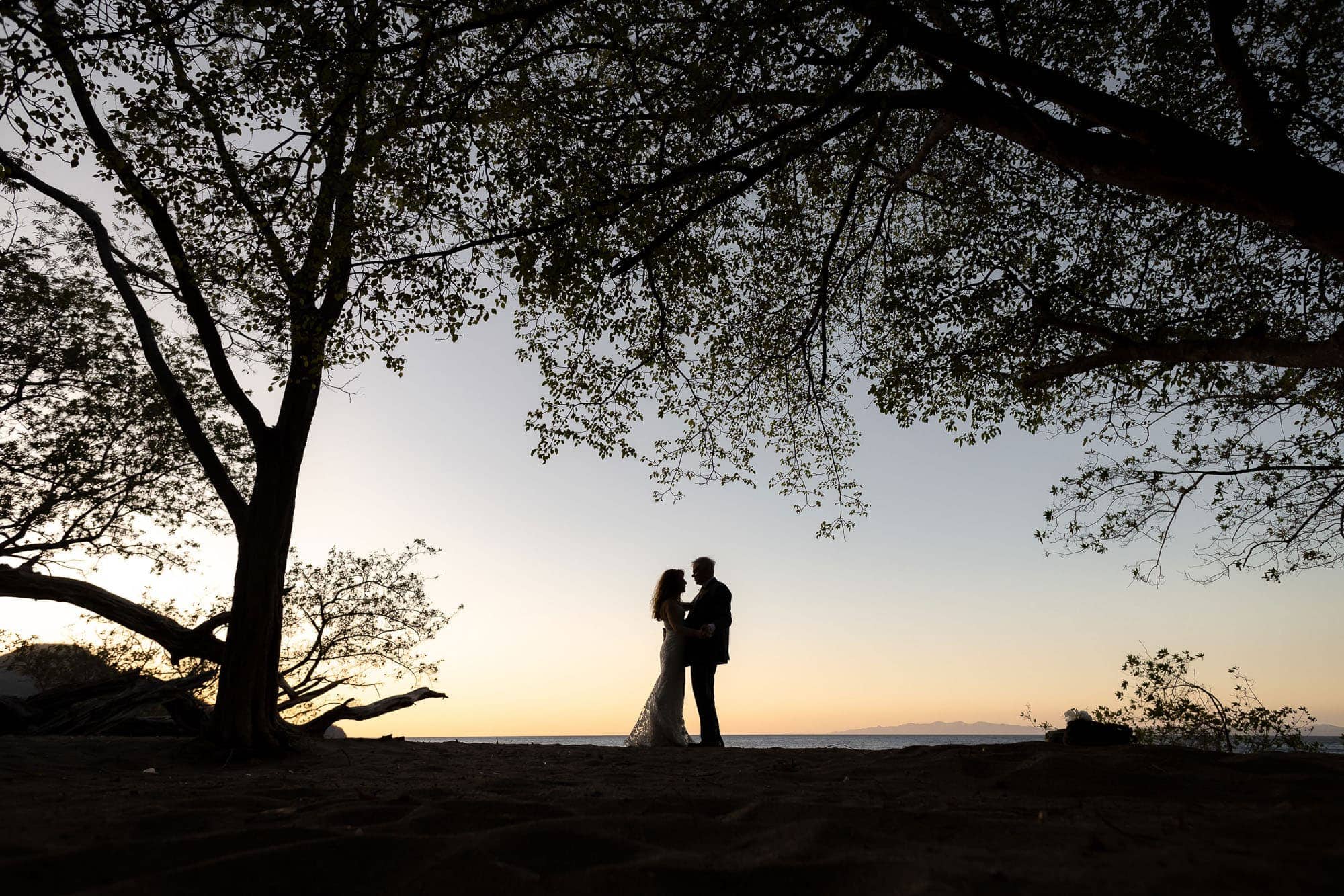 silhouette of bride and groom at sunset at riiu palace costa rica