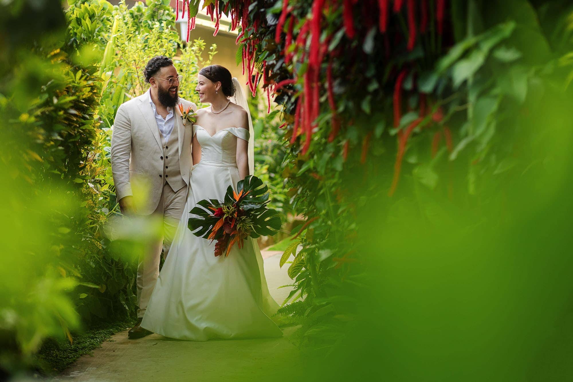 bride and groom stroll through the greenery at La Mariposa Hotel