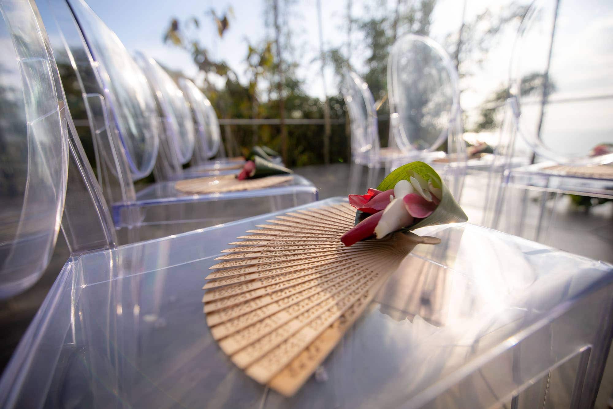 easy way to plan a wedding in Costa Rica: let the professionals add flowers and fans to the guests' chairs