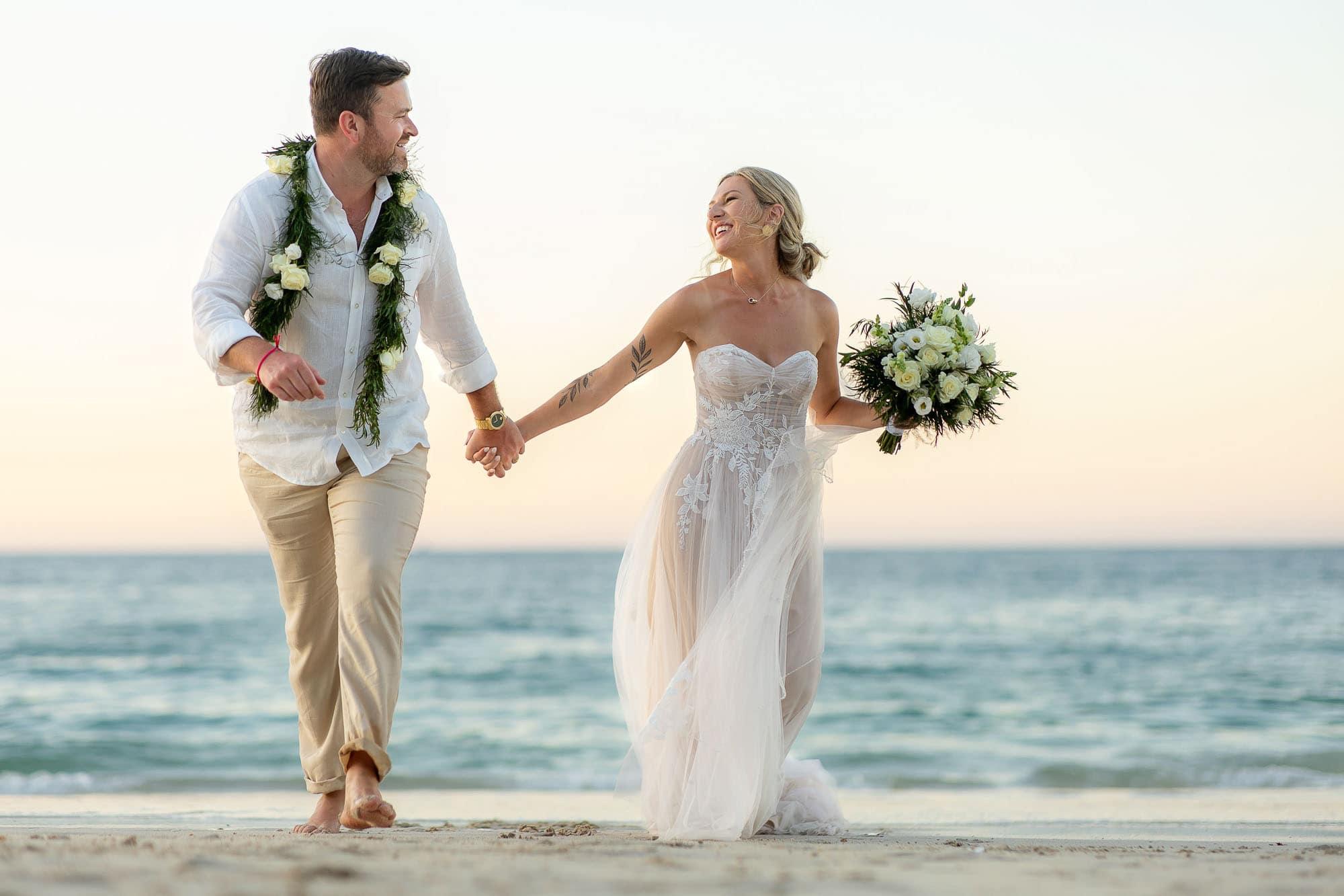 bride and groom running on the beach in Costa Rica